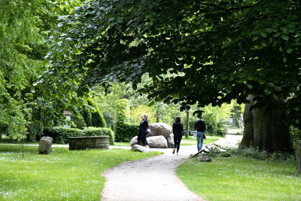 Junge Frauen spazieren im Friedhof