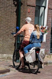 Oma, Enkelin mit Blumenstrauss und Krücke sind auf dem Fahrrad!